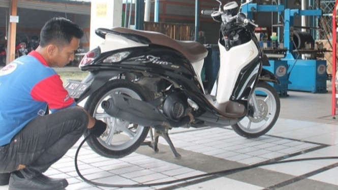 Isi tekanan angin pada motor.