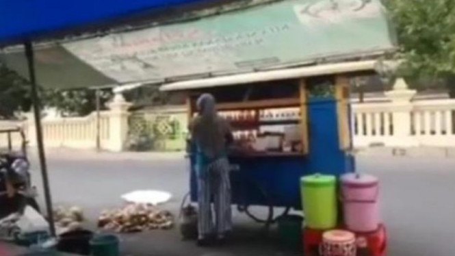 Penjual es kelapa muda di tengah-tengah arena road race.