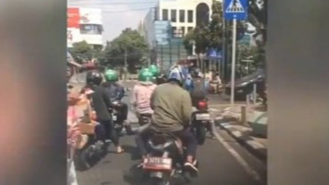 Biker ogah turunin kaki di lampu merah.