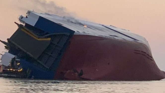 Kapal kargo angkut ribuan mobil baru terbalik.