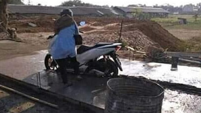 Emak-emak nekat terobos coran basah.