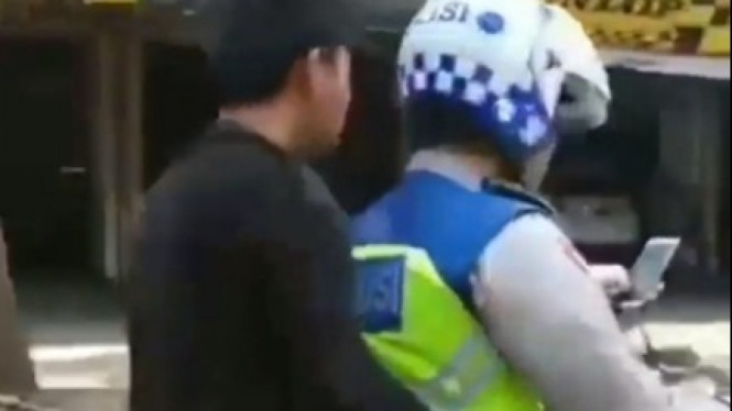 Polisi naik motor sambil main hape