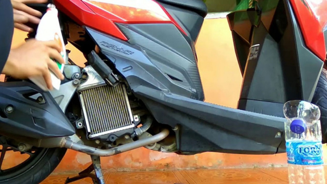 Mengisi radiator motor.