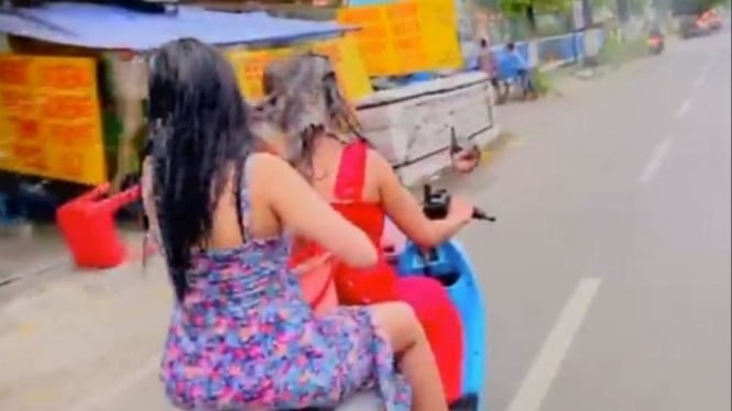Dua wanita nekat mandi di atas motor.