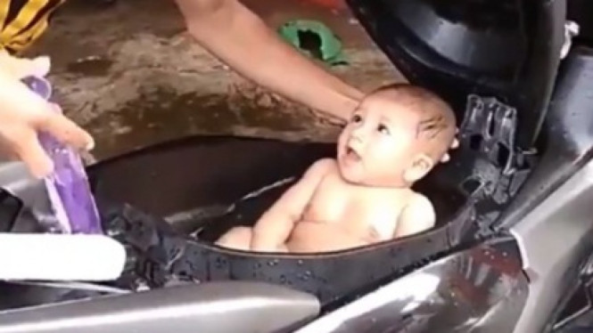 Memandikan bayi di bagasi motor
