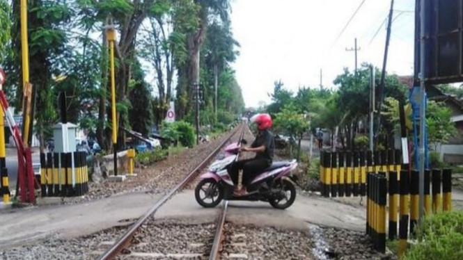 Naik motor lewat rel