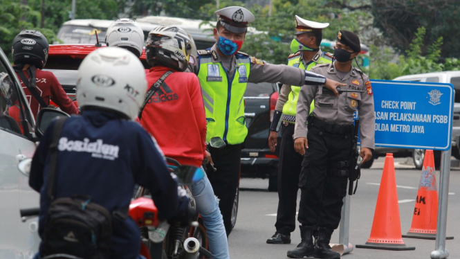 Petugas Kepolisian memeriksa kendaraan yang melintas saat PSBB