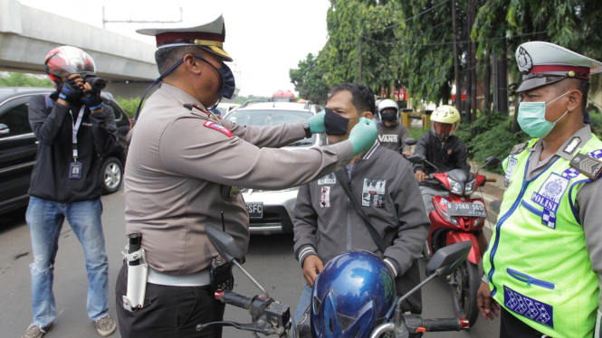 Petugas Kepolisian memeriksa kendaraan yang melintas saat PSBB