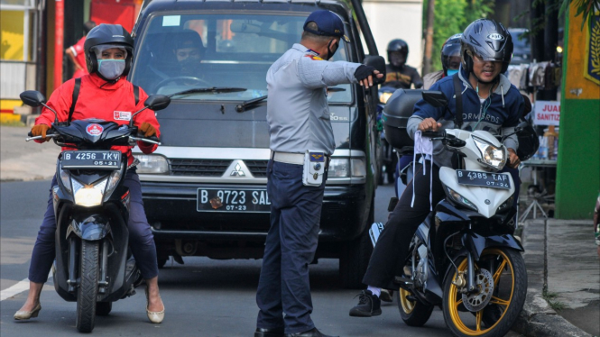 Petugas Kepolisian memeriksa kendaraan yang melintas saat PSBB