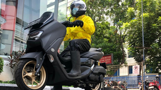 Berkendara pakai jas hujan