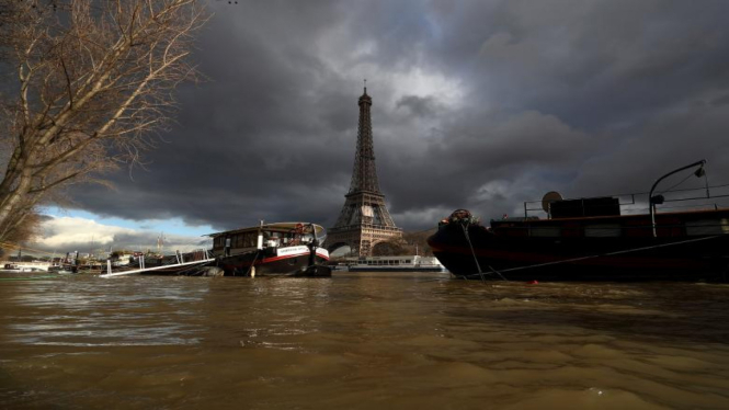 A view shows peniche houseboats moored and the Eiffel Tower along the flooded banks of the River Seine after days of almost non-stop rain caused flooding in the