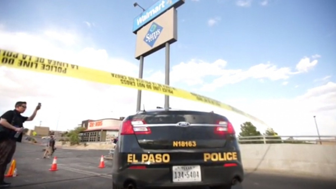 A police officer stands next to a police cordon after a mass shooting at a Walmart in El Paso