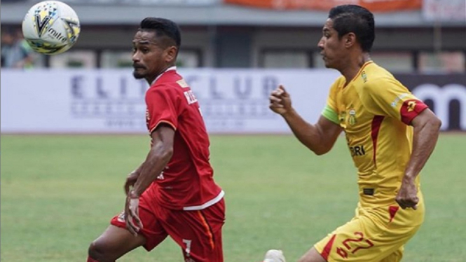 Gelandang Persija, Ramdani Lestaluhu dijaga ketat kapten Bhayangkara FC, Indra Kahfi saat kedua tim bermain imbang 1-1