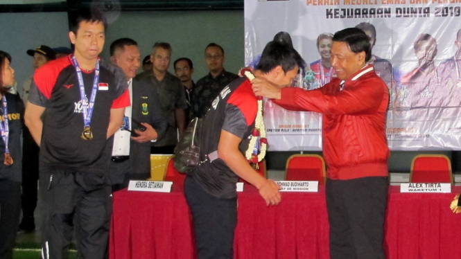 Ahsan-Hendra mendapat pengalungan bunga dari Ketua Umum PP PBSI Wiranto