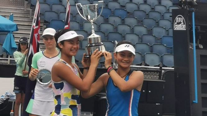 Petenis belia Indonesia, Priska Madelyn Nugroho (kanan), dan petenis Filipina, Alexandra Eala, mengangkat trofi juara ganda putri Grand Slam Australia Terbuka J