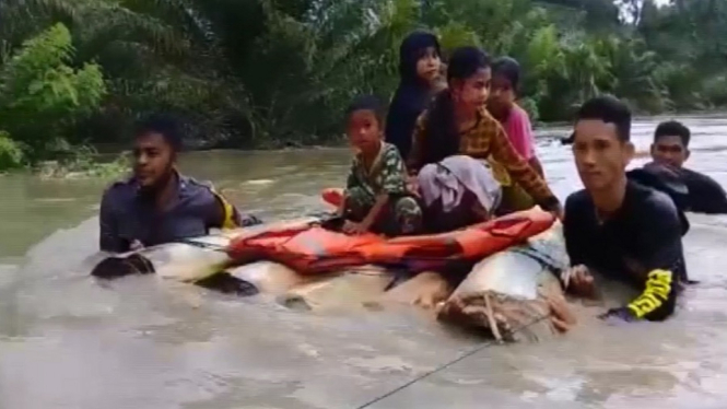 Proses Evakuasi Warga Desa Ompi menggunakan Rakit Batang Pisang (ANTV/Gusni Kardi)
