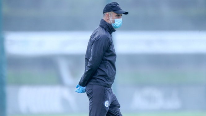 Pep Guardiola memakai masker saat memimpin latihan Manchester City