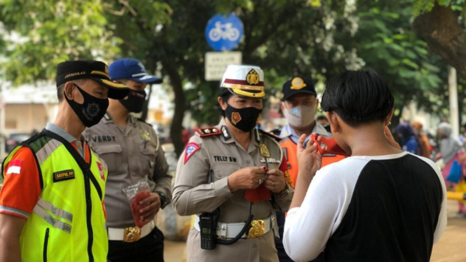 Satlantas Polrestro Jakarta Timur Peduli Prokes Bagikan Masker di Wilayah BKT (Foto Humas Polres Metro Jakarta Timur)