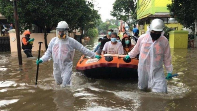 Saat Petugas Medis Evakuasi Seorang Warga Positif Covid-19 di Tengah Banjir (Foto Ilustrasi Evakuasi Pasien Positif Covid-19)
