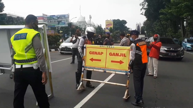 Sejumlah petugas sedang memasang plang ganjil genap yang kembali diberlakukan di Kota Bogor. Sabtu (19/6)Pagi. ( Foto : Usep Saripudin/ANTV)