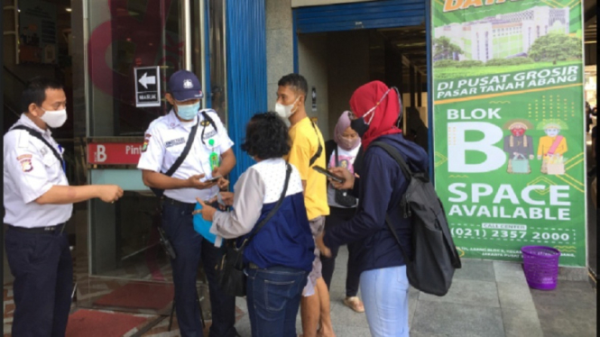 Petugas meminta warga menunjukan sertifikat vaksin sebagai syarat masuk ke dalam Pasar Tanah Abang. (ANTV/ Emzy Ardiwinata)