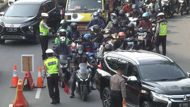 Sejumlah petugas kepolisian sedang mengatur arus lalulintas di jalur penyekatan di Kawasan Pasar Gembrong, Jakarta Timur. ( Foto : Johannes Bosko/ANTV)