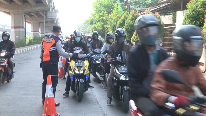 Seorang pengendara bermotor menunjukkan STRP via telpon gengamnya kepada petugas untuk bisa lolos masuk ke tanah abang. (Foto: Tilkaihwanul Ghofur/ANTV)