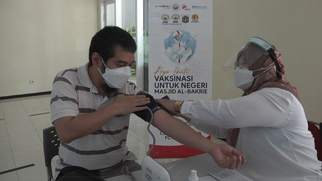 Seorang jama’ah masjid sedang mendapat layanan vaksinasi dari bakrie Amanah yang di gelar di masjid bakrie Al-Bakrie, Setiabudi, Jakarta Selatan. (Foto : Wisnu 