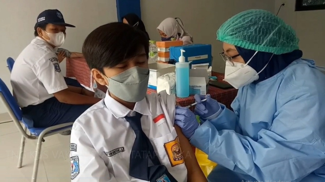 Seorang siswa SMP sedang menjalani vaksinasiCovid-19. Vaksinasi siswa dan guru dijadikan sebagai syarat dibukanya pembelajaran tatap mukan di Kota Tengerang. ( 