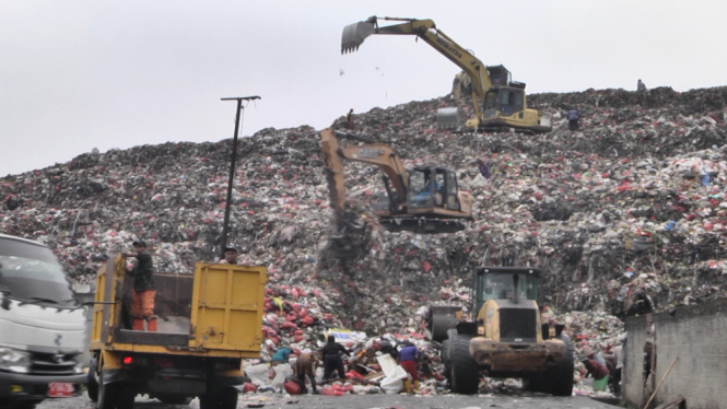 Eskavator dan Buldozzer sedang melayani pembuangan sampah