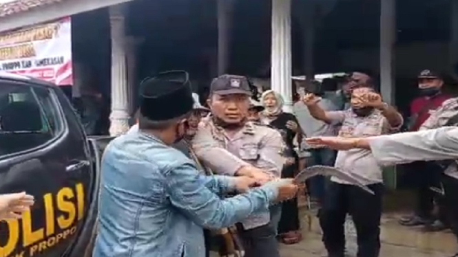 Polisi mencoba menenangkan pendukun Cakades yang kecewa hingga mengeluarkan clurit