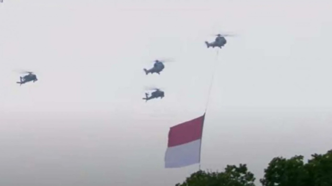 Helikopter TNI Tiga Matra membawa bendera.