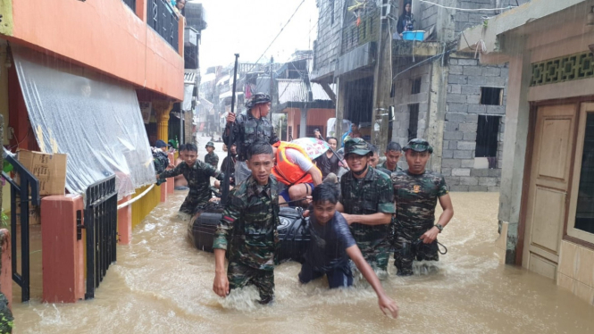 Prajurit TNI AD evakuasi warga korban banjir di Kota Manado.