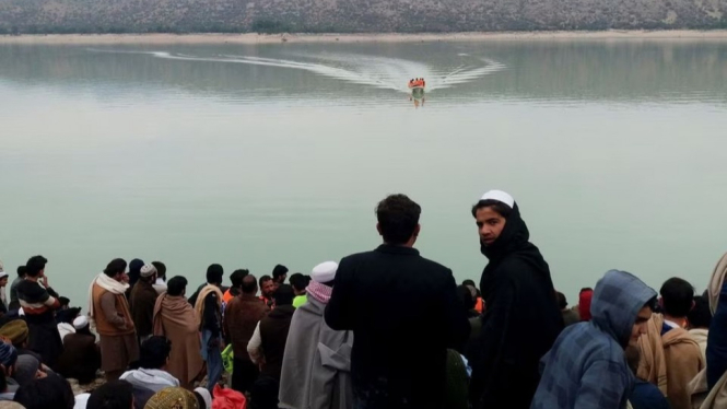 Warga kumpul di pinggir danau menunggu proses evakuasi di Pakistan.