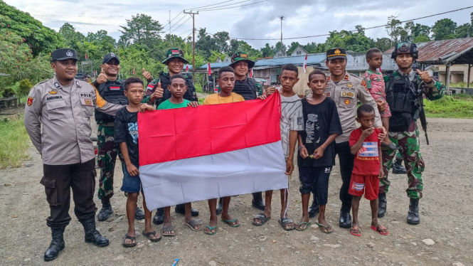 Satgas Yonif 122/TS dan Polsek Arso Timur Bagikan Bendera Merah