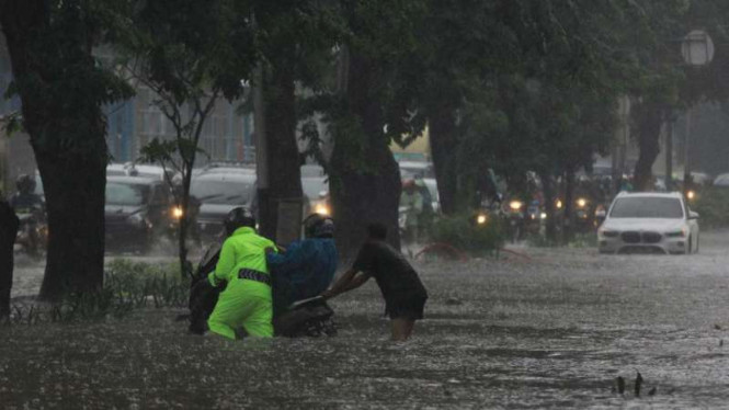 Ilustrasi polisi bantu warga saat banjir.