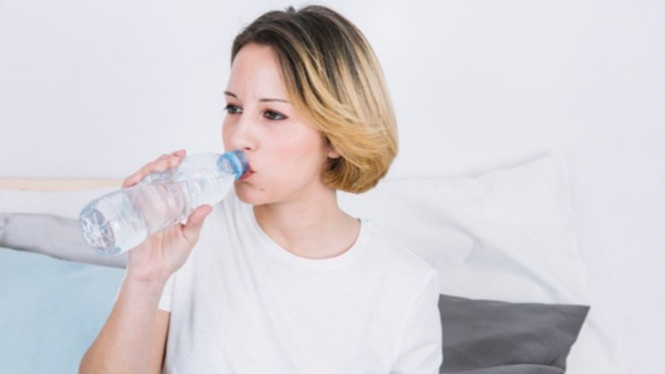 Ilustrasi minum air mineral.