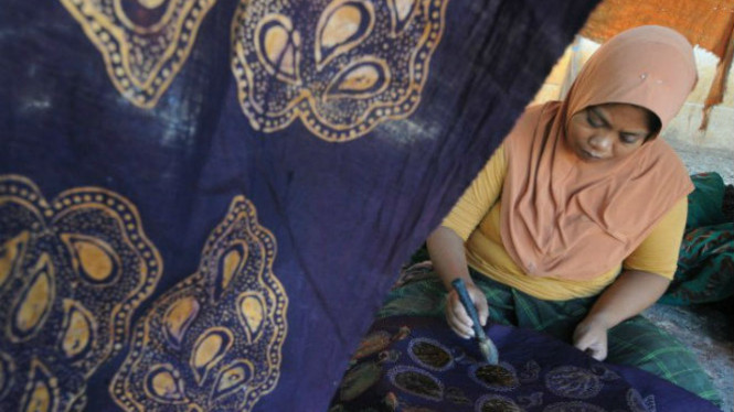 Perajin sedang membuat motif batik.