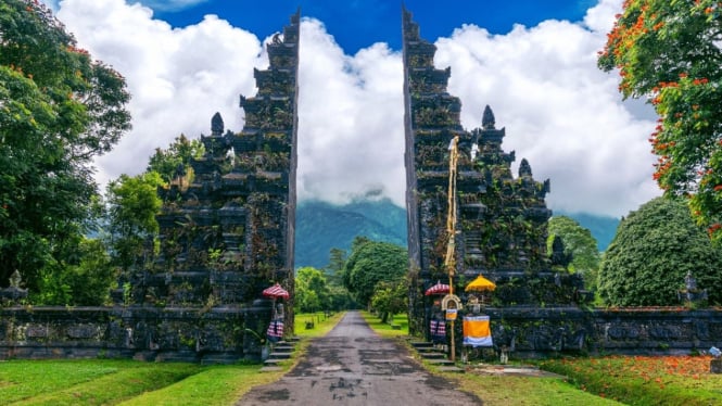 Gerbang megah ala Bali dengan latar pegunungan berkabut