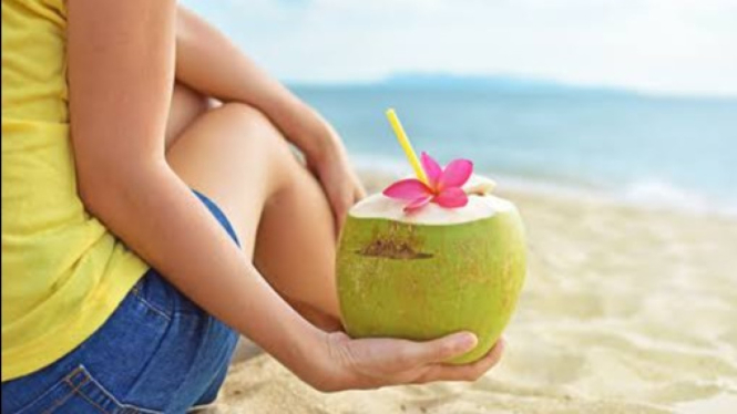 Berlibur ke pantai identik dengan minum air kelapa