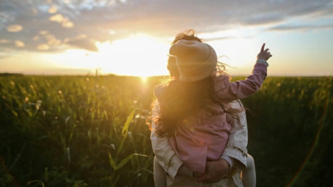 Ibu dan anak berjemur di bawah matahari