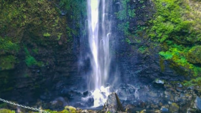 Pesona Air Terjun Coban Rondo dikelilingi bebatuan.
