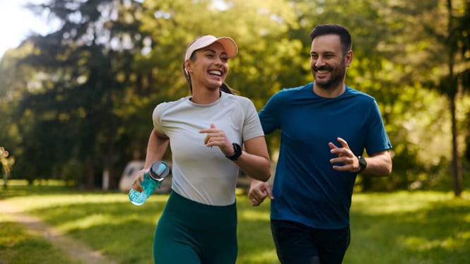 Pasangan atletik jogging melewati taman