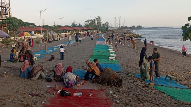 Wisatawan Menunggu Sunset Tenggelam di pesisir pantai