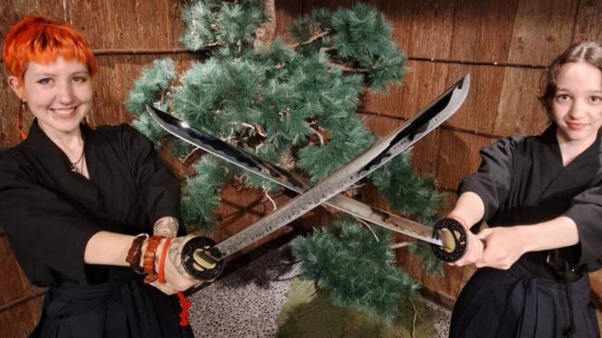 Wisatawan asing mengikuti kursus bela diri dengan pedang katana