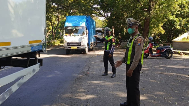 Petugas lalu lintas saat mengatur kemacetan di jalur Pantura