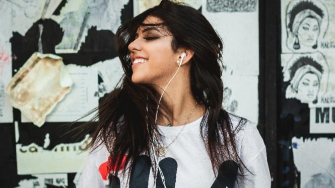 Ilustrasi Wanita sedang menggunakan Earphone.