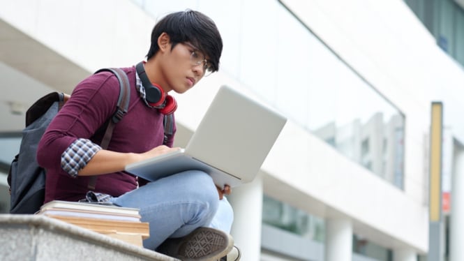 Mahasiswa sedang belajar dengan laptopnya