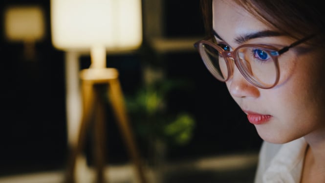 Wanita berkacamata sedang menatap layar