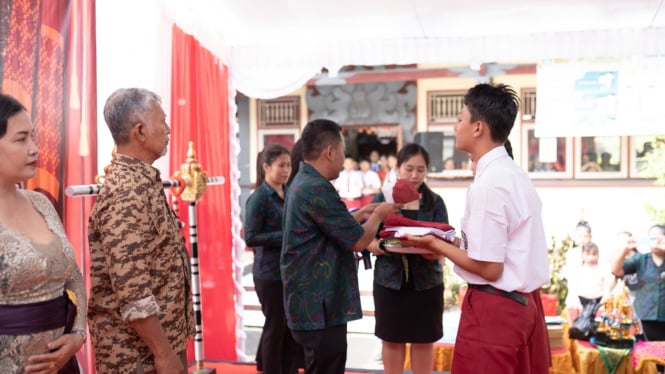 Siswa SDN 3 Dauhwaru menyerahkan Pakaian kepada Kepala Sekolah